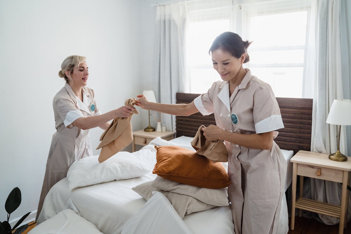 Housekeepers changing bed sheets as a team